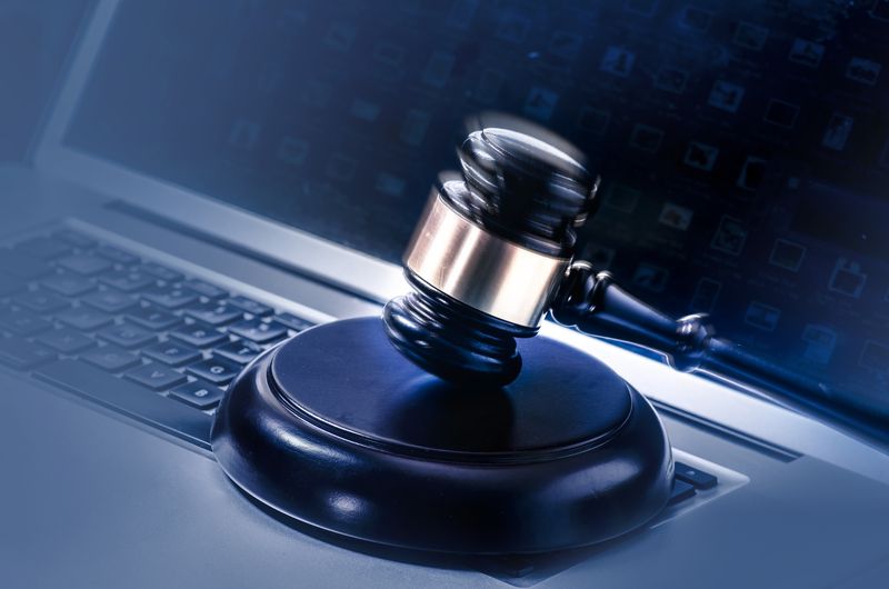 A gavel sitting on top of a laptop.