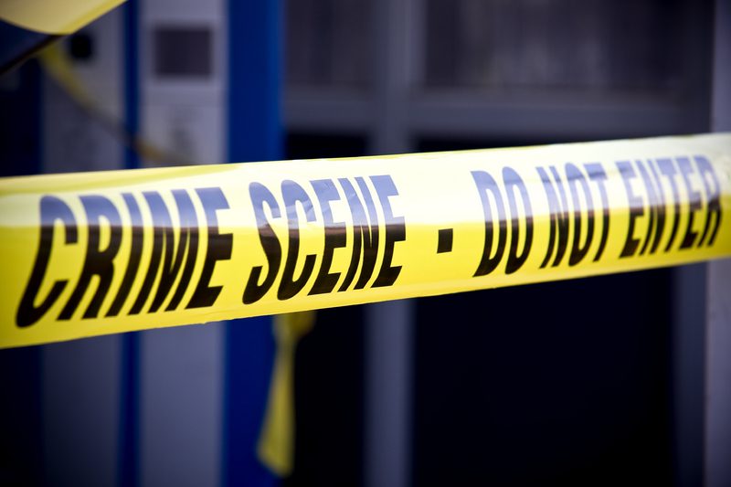 A yellow police tape with the words " crime scene " written on it.